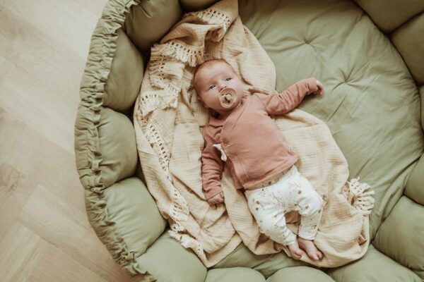 PlayandGo_organic_babymat_Bloom_meadow_green_baby_with_pacifier_lying_on_mat_raised_edges Play&Go 3u1 Bloom podloga za igru i gnijezdo za bebe - Meadow Green - Image 18