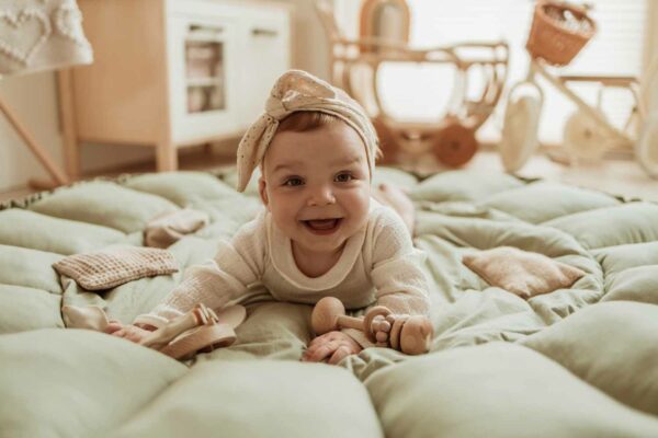 PlayandGo_organic_babymat_Bloom_meadow_green_child_lying_on_open_mat_laughing Play&Go 3u1 Bloom podloga za igru i gnijezdo za bebe - Meadow Green - Image 17