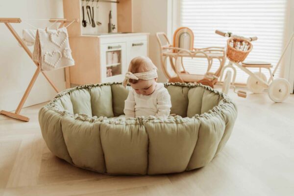 PlayandGo_organic_babymat_Bloom_meadow_green_child_sitting_on_mat_raised_edges Play&Go 3u1 Bloom podloga za igru i gnijezdo za bebe - Meadow Green - Image 13