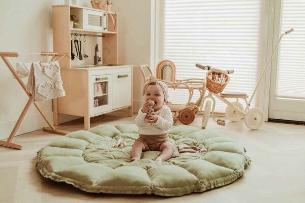 PlayandGo_organic_babymat_Bloom_meadow_green_child_sitting_on_open_mat_in_kidsroom Play&Go 3u1 Bloom podloga za igru i gnijezdo za bebe - Meadow Green - Image 12