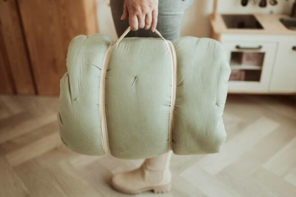 PlayandGo_organic_babymat_Bloom_meadow_green_person_carrying_mat_as_bag Play&Go 3u1 Bloom podloga za igru i gnijezdo za bebe - Meadow Green - Image 7