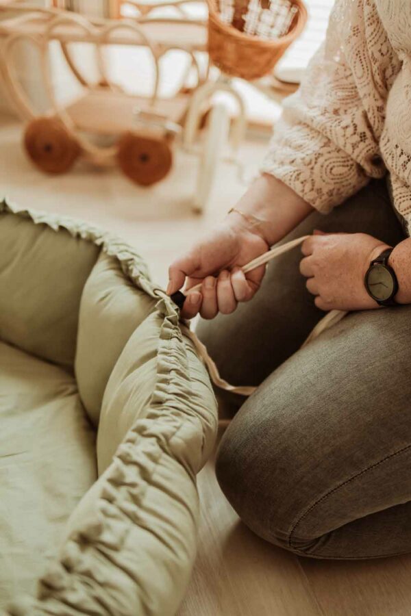 PlayandGo_organic_babymat_Bloom_meadow_green_person_pulling_the_ropes (1) Play&Go 3u1 Bloom podloga za igru i gnijezdo za bebe - Meadow Green - Image 6