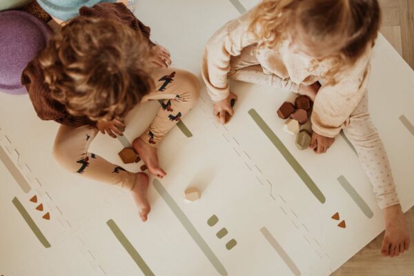 PlanandGo_EEVAA_farm_puzzlemat_backside_stripes_and_icons_children_are_sitting_on_the_mat_playing_with_wooden_blocks Play&Go 3u1 EEVAA dvostrana podloga za igru – Farma (120x180cm) - Image 24