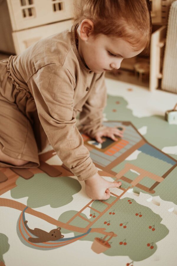 PlayandGo_EEVAA_treehouse_puzzlemat_child_is_making_a_puzzle_of_the_mat Play&Go 3u1 EEVAA dvostrana podloga za igru – Kućica na drvetu/Zvjezdice (120x180cm) - Image 18