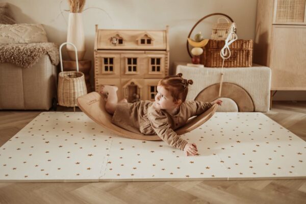 PlayandGo_EEVAA_treehouse_puzzlemat_child_lying_on_a_wooden_swing_board_on_the_mat Play&Go 3u1 EEVAA dvostrana podloga za igru – Kućica na drvetu/Zvjezdice (120x180cm) - Image 14