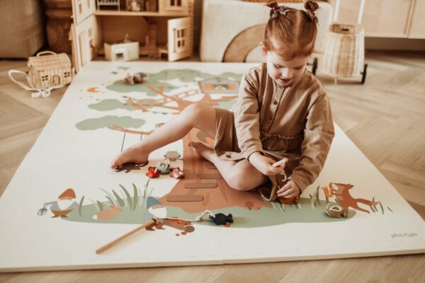 PlayandGo_EEVAA_treehouse_puzzlemat_child_sitting_on_the_mat_playing_with_wooden_toys Play&Go 3u1 EEVAA dvostrana podloga za igru – Kućica na drvetu/Zvjezdice (120x180cm) - Image 8