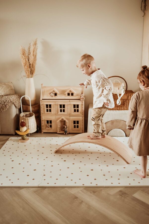 PlayandGo_EEVAA_treehouse_puzzlemat_children_are_playing_on_the_mat_with_stars_print_with_a_wooden_swing_board_one_child_is_standing_on_top Play&Go 3u1 EEVAA dvostrana podloga za igru – Kućica na drvetu/Zvjezdice (120x180cm) - Image 33