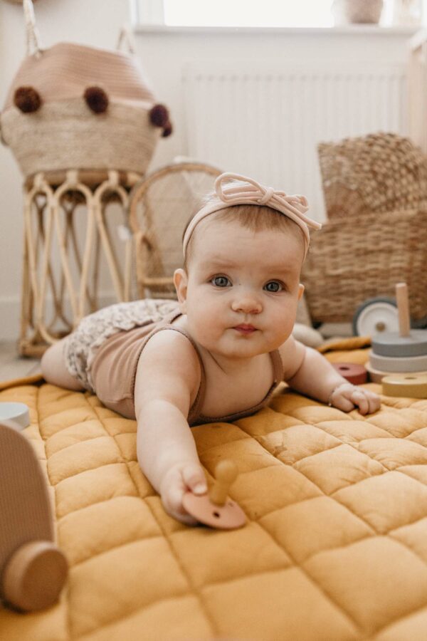 Playandgo_organic_collection_playmat_open_detail_mustard_chai_tea_wooden_toys_baby_playing_on_mat_with_pacifier Play&Go 3u1 Soft Organic - Mustard Chai Tea - podloga za igru - Image 2