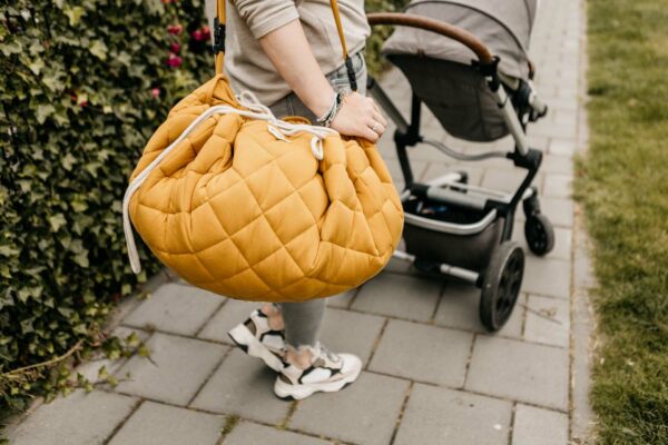 Playandgo_organic_collection_quilted_babymat_woman_carying_bag_detail_mustard_chai_tea (1) Play&Go 3u1 Soft Organic - Mustard Chai Tea - podloga za igru - Image 16