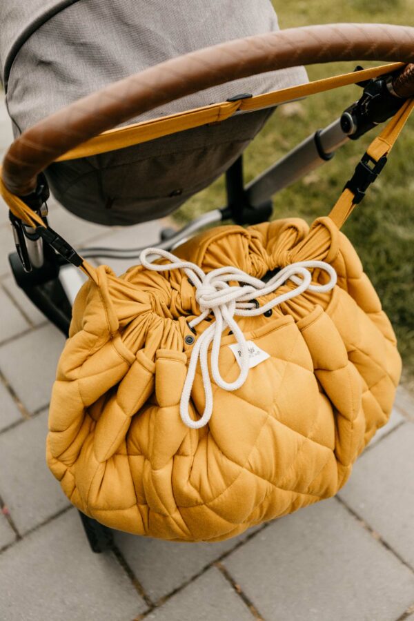Playangdo_organic_collection_quilted_babymat_closed_hanging_on_pram_detail_mustard_chai_tea (1) Play&Go 3u1 Soft Organic - Mustard Chai Tea - podloga za igru - Image 12