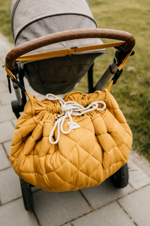 Playangdo_organic_collection_quilted_babymat_closed_hanging_on_pram_detail_mustard_chai_tea Play&Go 3u1 Soft Organic - Mustard Chai Tea - podloga za igru - Image 11